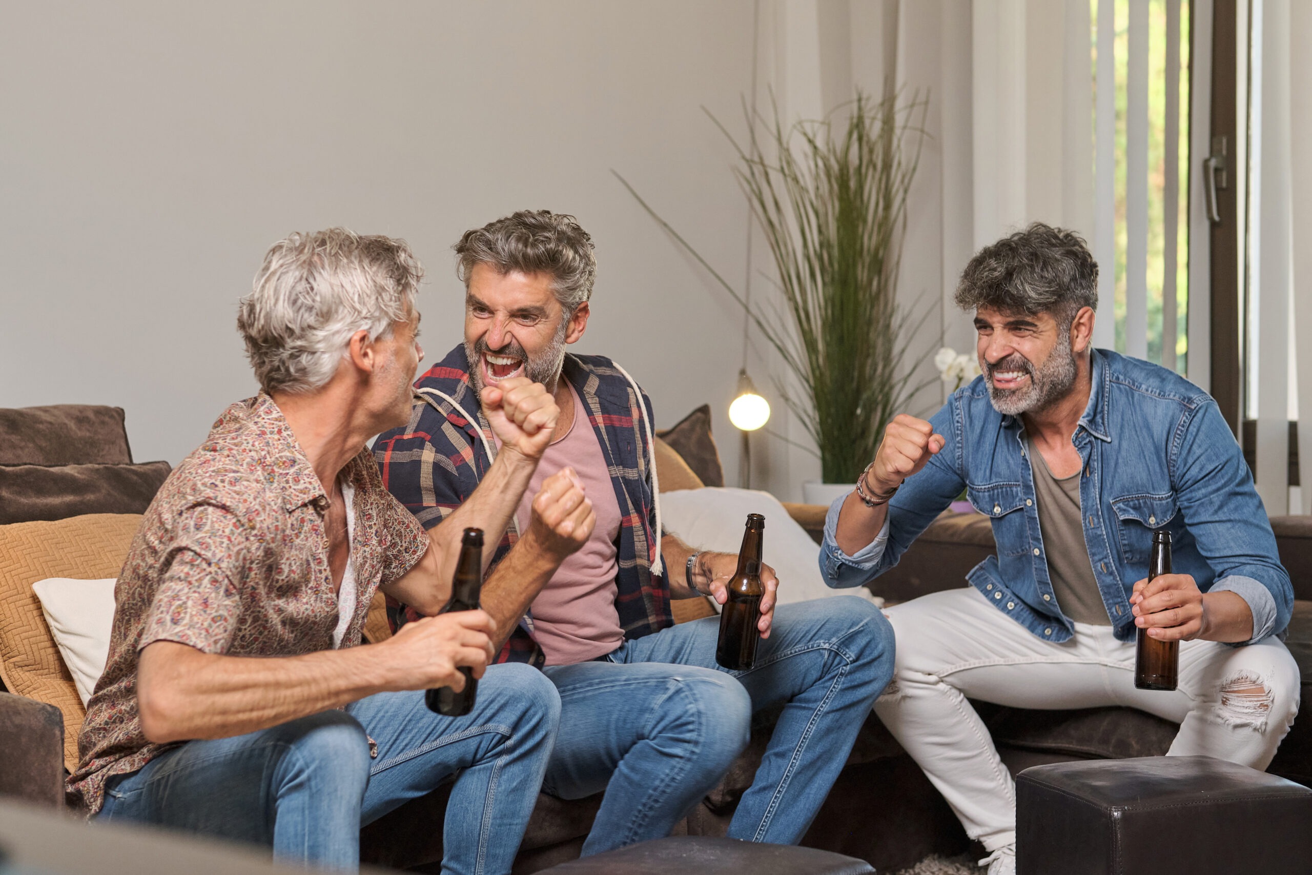 men drinking beer and celebrating victory at home 2025 04 03 07 04 59 utc scaled
